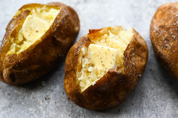 Baked potatoes with crispy skins and fluffy insides, lightly salted.